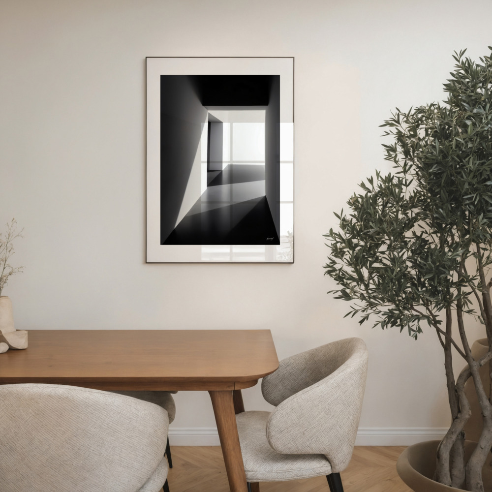 Black and white architectural corridor print above mid-century table with chairs and plants.