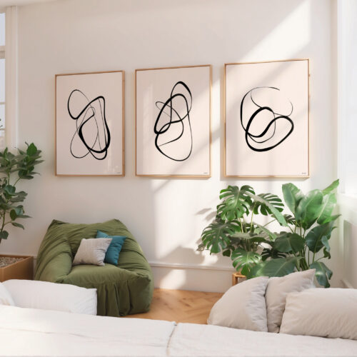 Three minimalist line art prints displayed above a green sofa in bright living room.