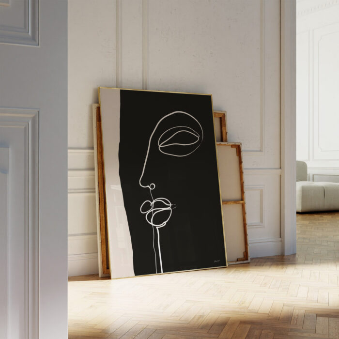 Minimalist black canvas with abstract white face line drawing leaning against bright wall.