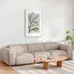 Minimalist living room with beige sofa, botanical line art, and natural light.