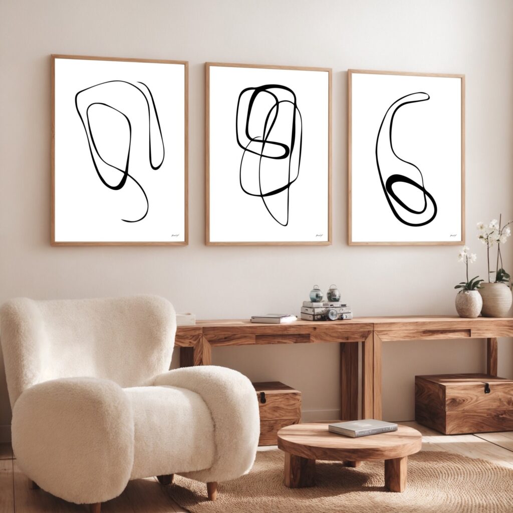 Three abstract line art prints above wooden console in minimalist living room.