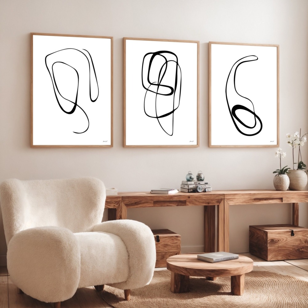 Three abstract line art prints above wooden console in minimalist living room.