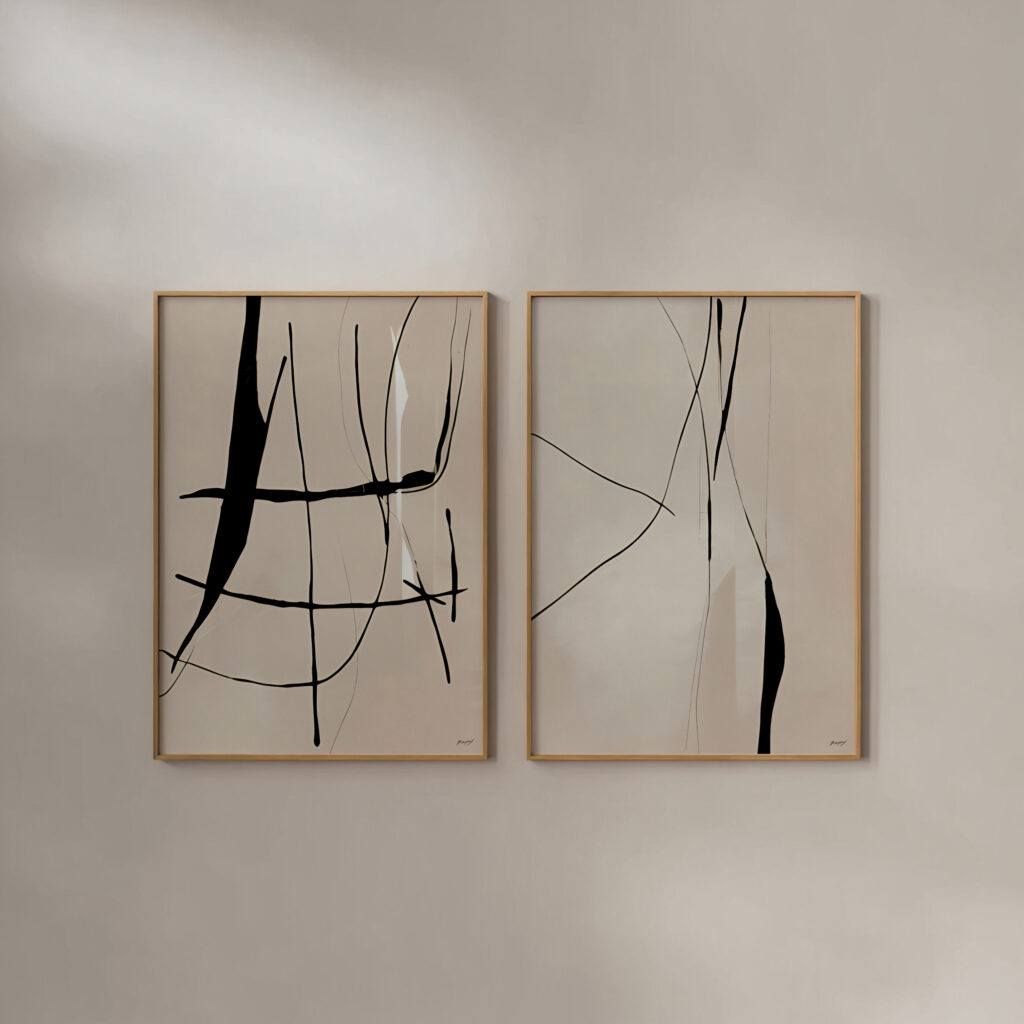 Minimalist black line art abstract prints in wooden frames, mounted on white wall.