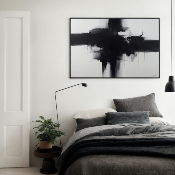 Minimalist bedroom with bold black abstract art above layered gray bedding.