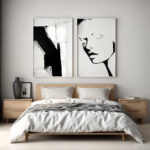 Modern bedroom with wooden bed frame and striking black and white art prints.