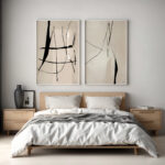 Minimalist bedroom with twin abstract black brushstroke art above wooden bed.
