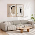 Abstract line art diptych hanging above gray sofa in minimalist living room.