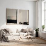 Modern living room with beige sofa, abstract black-beige artwork, and natural accents.