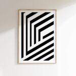 Minimalist black and white geometric wall art in wooden frame against white background.