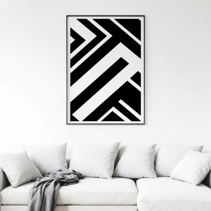 Bold geometric black and white art above elegant white sectional sofa with gray throw blanket.