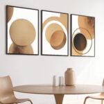 Abstract circle triptych in earth tones above minimalist round dining table.