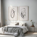 Elegant black abstract line art prints above minimalist bed with neutral decor