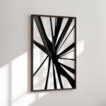 Abstract black starburst pattern on white background in minimal wooden frame.