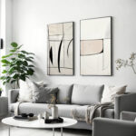 Minimalist abstract line art prints in neutral living room with gray sofa.
