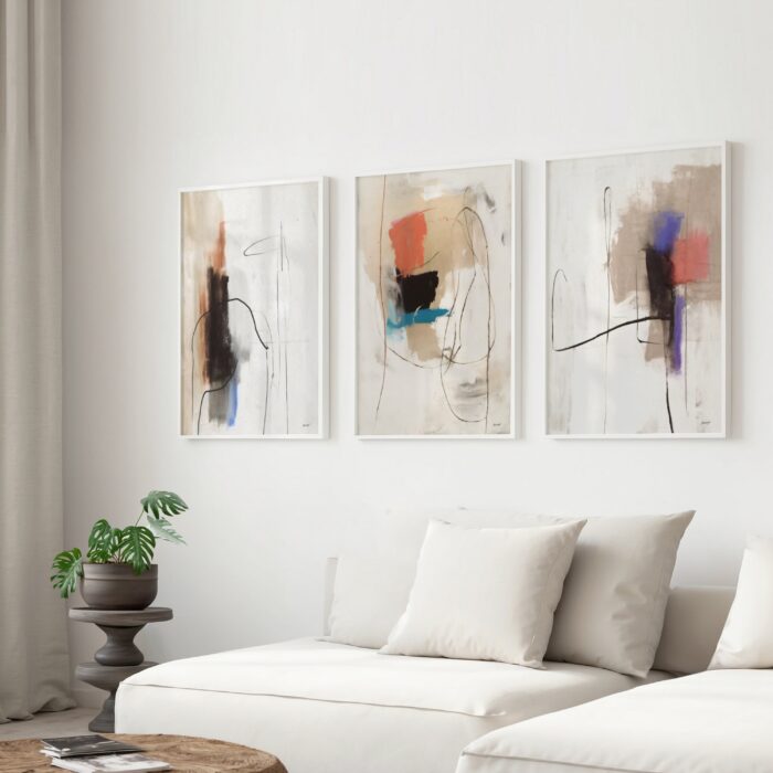 Abstract triptych artwork in soft neutrals above white sofa with small plant