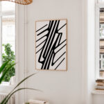 Minimalist black line geometric wall art in bright modern interior with plants.