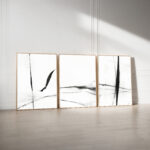 Abstract black ink triptych art displayed against white wall in minimalist gallery setting.