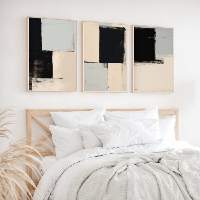 Modern abstract triptych artwork above bed in minimalist white and neutral bedroom.