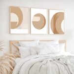 Minimalist bedroom with beige circular abstract art prints above wooden bed