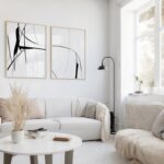 Minimalist living room with sleek white furniture and black abstract wall art