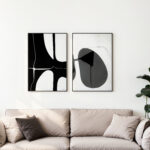 Modern black and white abstract art displayed above a beige sofa with neutral pillows.