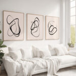 Minimalist black line art trio above white sofa in bright, airy living room.
