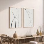 Minimalist abstract line art frames above wooden console with ceramic decor pieces.