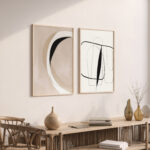 Minimalist abstract line art paired with natural wood console and ceramic vessels.