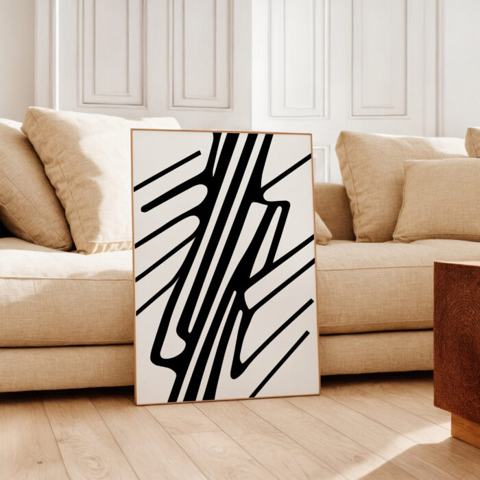 Abstract black and white line art against beige sofa in minimalist living room.
