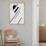 Black and white geometric abstract art print on mint green wall with wooden chair