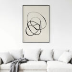 Elegant abstract black line art framed above white sofa in minimalist living room.