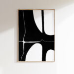 Black and white abstract geometric art in wooden frame on white wall