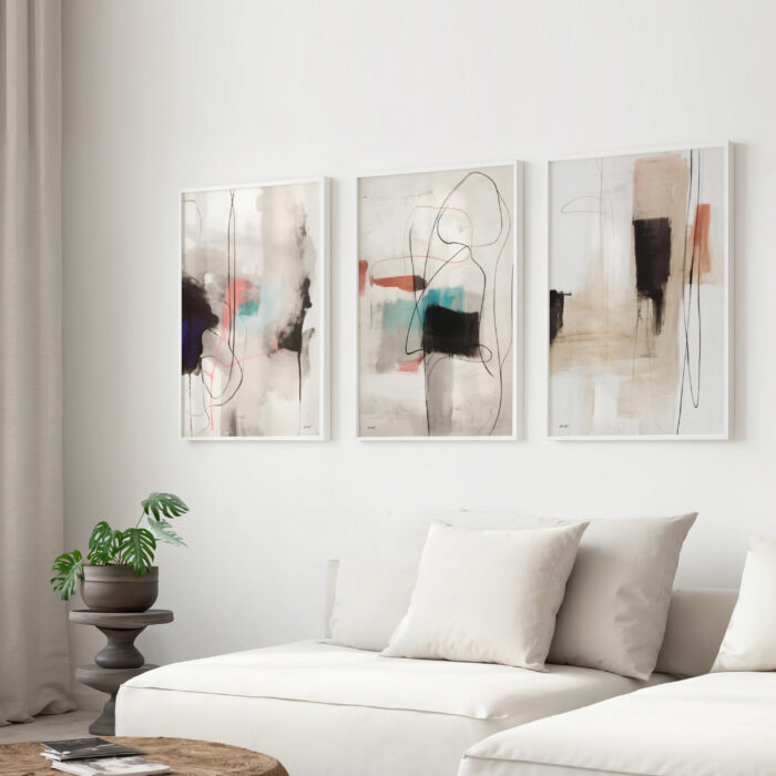 Abstract triptych in neutral tones with teal accents above white sectional sofa.