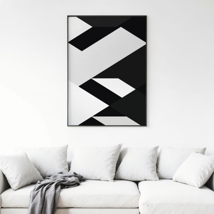 Bold geometric black and white abstract art print above white sofa with cushions