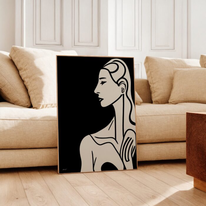 Black silhouette figure art print leaning against beige sofa in modern living room.