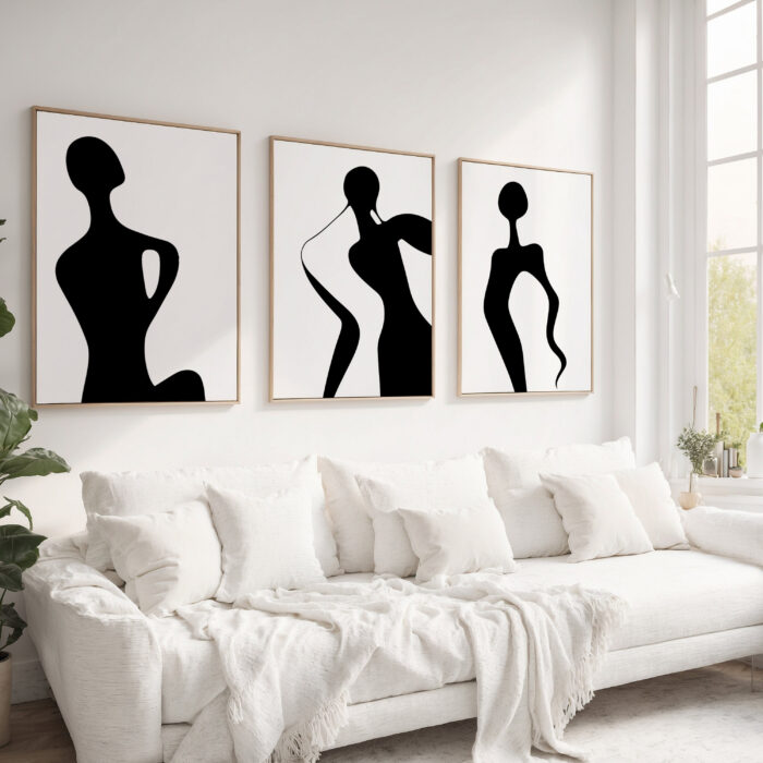 Modern black silhouette art trio above white sofa in minimalist living room