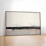 Minimalist abstract horizon painting with black stroke on cream canvas against white wall