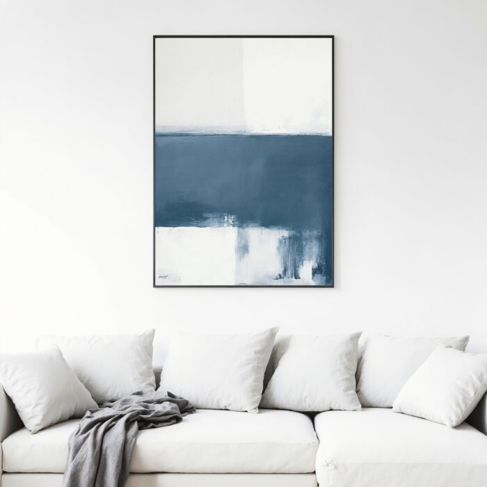 Abstract blue and white artwork mounted above neutral sofa with decorative cushions.
