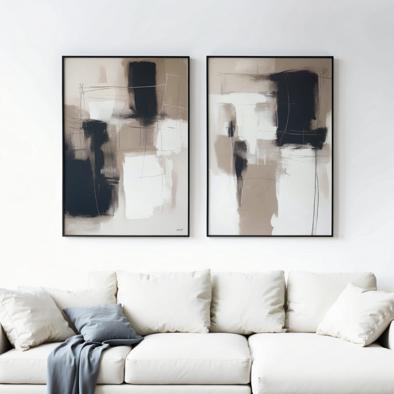 Abstract black and white framed artwork hanging above a white sofa with cushions.