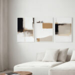 Minimalist abstract triptych artwork over white sofa in contemporary neutral living room