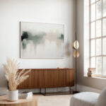 Abstract artwork over wooden credenza in bright minimalist living room with natural accents.