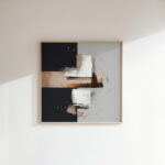 Elegant black and gray abstract painting in wooden frame on white wall.