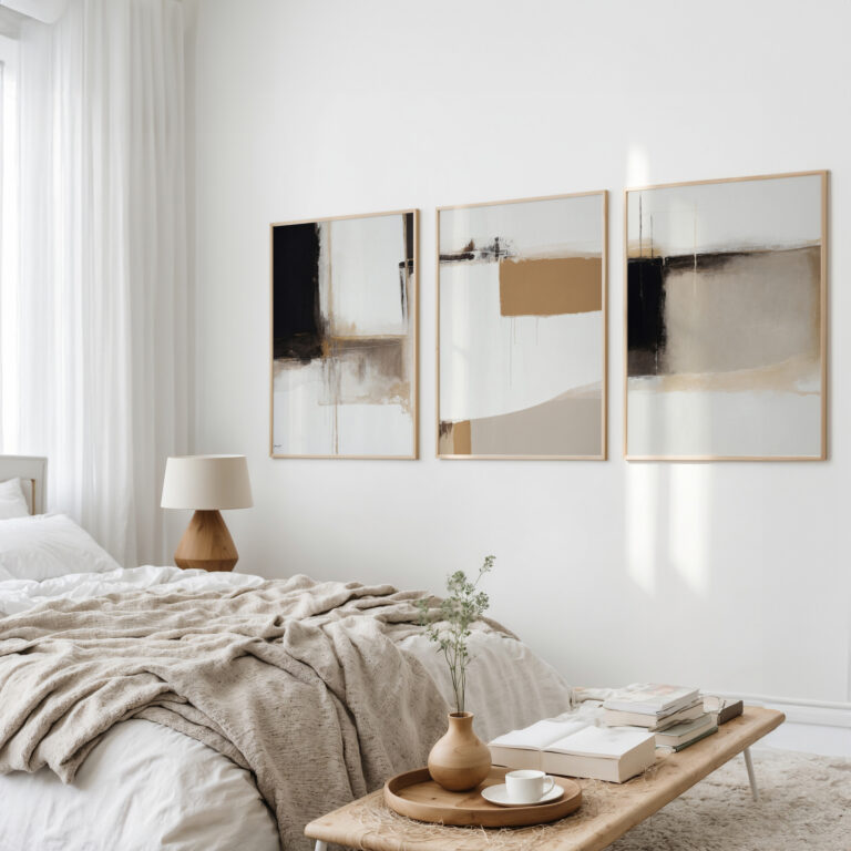 Minimalist bedroom with neutral toned abstract triptych art above layered beige bedding.