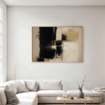 Minimalist living room with abstract black and beige artwork above white sofa.