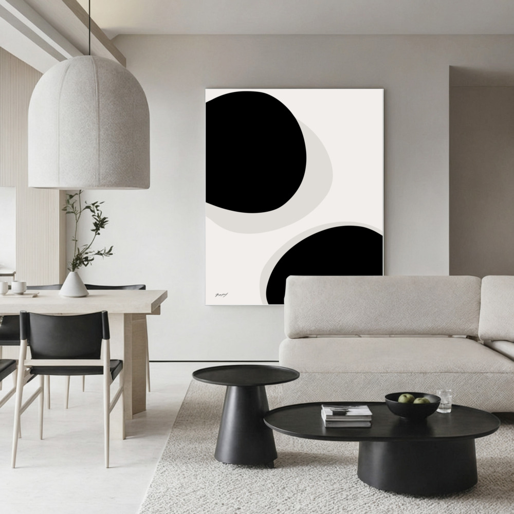 Minimalist black and white living room with striking abstract wall art and modern furniture.
