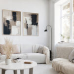 Minimalist living room with white sofa, neutral tones, and abstract wall art.