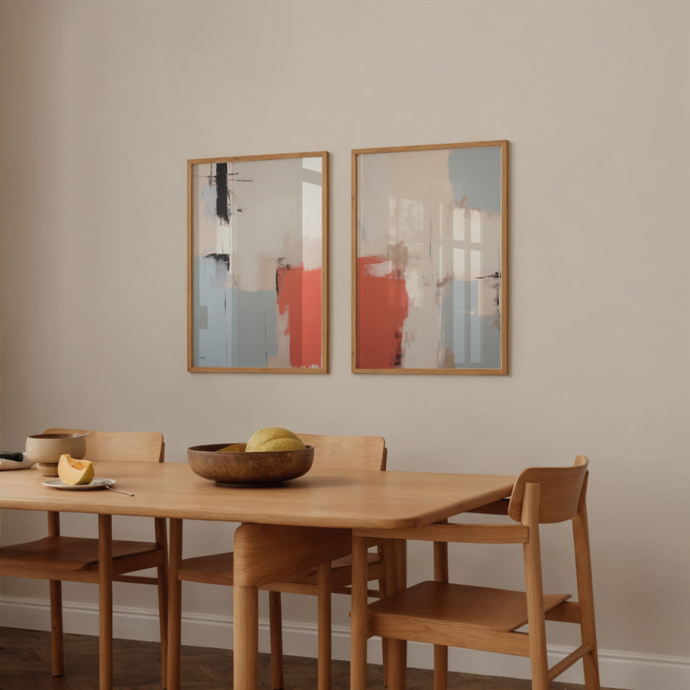 Abstract art duo hanging above wooden dining table with minimalist chairs.