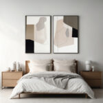 Abstract art diptych above bed in minimalist gray and beige bedroom setting.