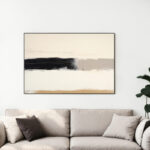 Abstract black brushstroke on cream canvas above beige sofa in modern living room.