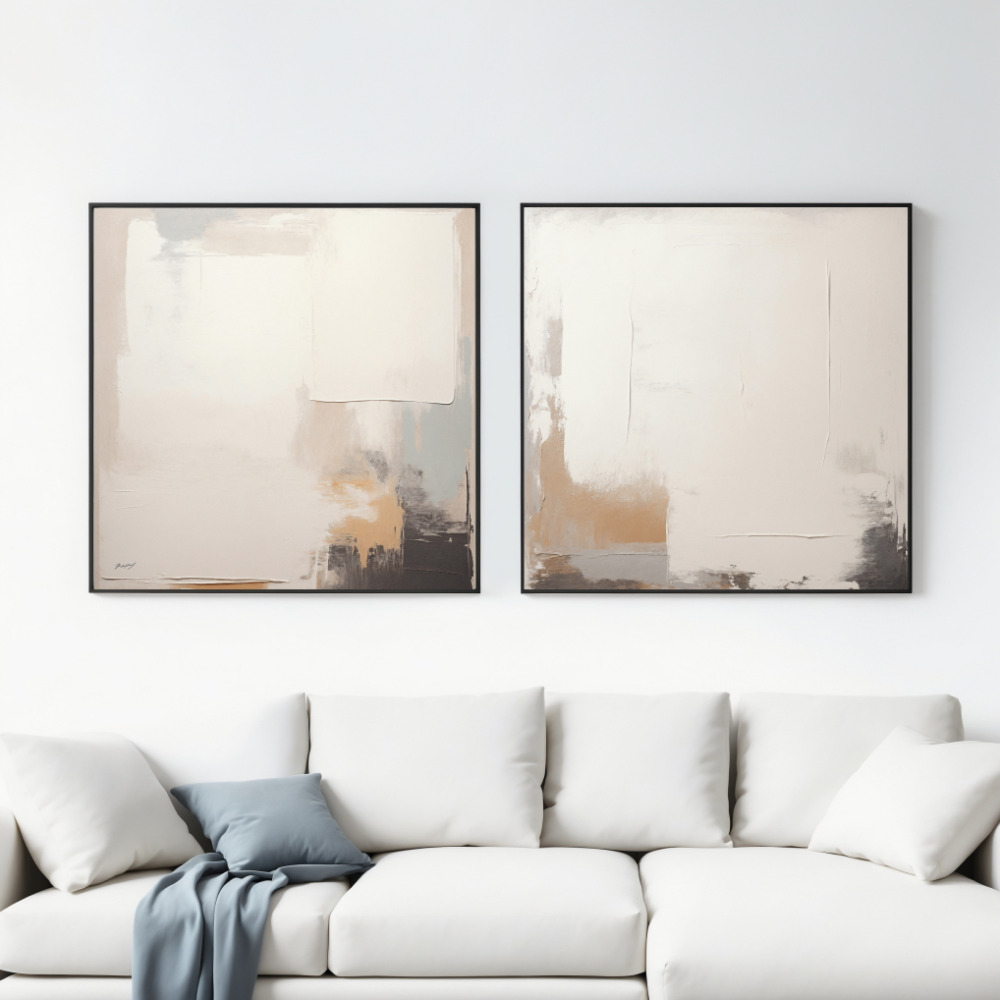 Two minimal abstract paintings in neutral tones hanging above a white sofa